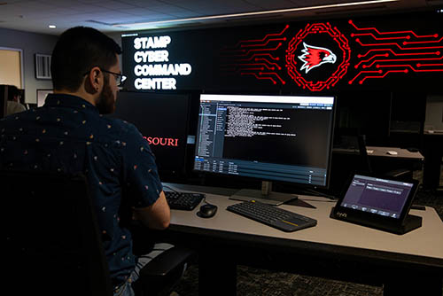 A student works with code at at computer console in the new cyber security facility, a full-scale cyber command center
