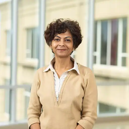 Headshot of Dr. Moutusy Maity the department of marketing chair standing in front of the windows at dempster. 