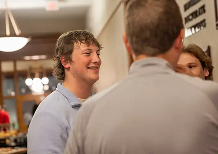 Two Male business students networking with alumni learning what jobs you can get with a marketing degree