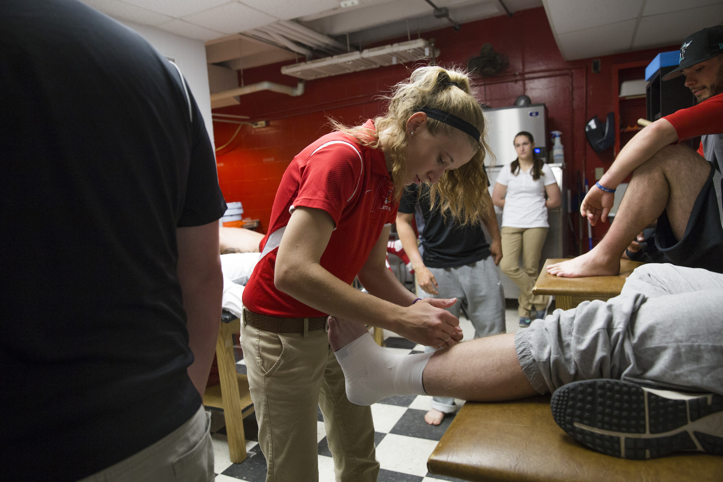 An athletic training student wraps the ankle of a peer.