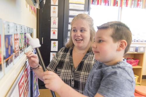 An Autism Center staffer works with a child.