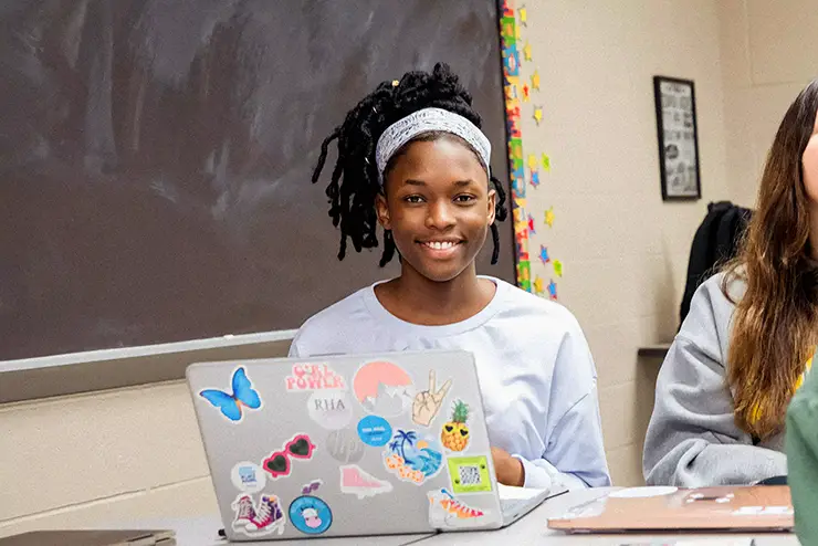 an education student at SEMO sits behind her laptop and smiles at the camera