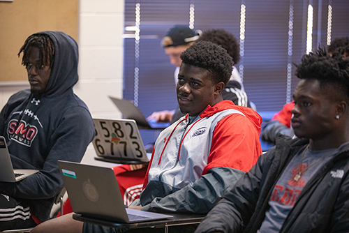 A group of SEMO students are taking notes on their computers during a sports management class.
