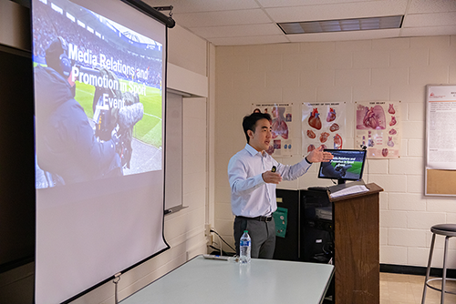 A teacher teaches a class about sports management.