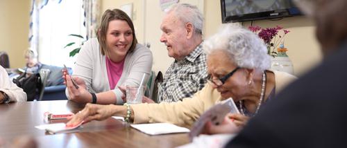 A Family Studies student holds playing cards for a patient at the Hoover Center.