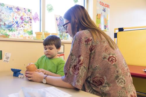 A Child and Family Studies student plays with a child at a table.