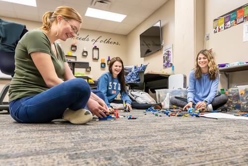 Students build LEGO robotics on the floor of the EDvolution Center.