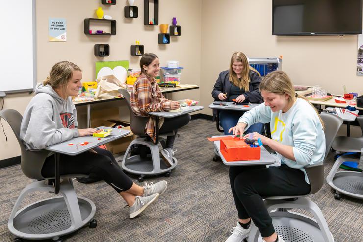 Students work together in the EDvolution Center while creating learning devices. 