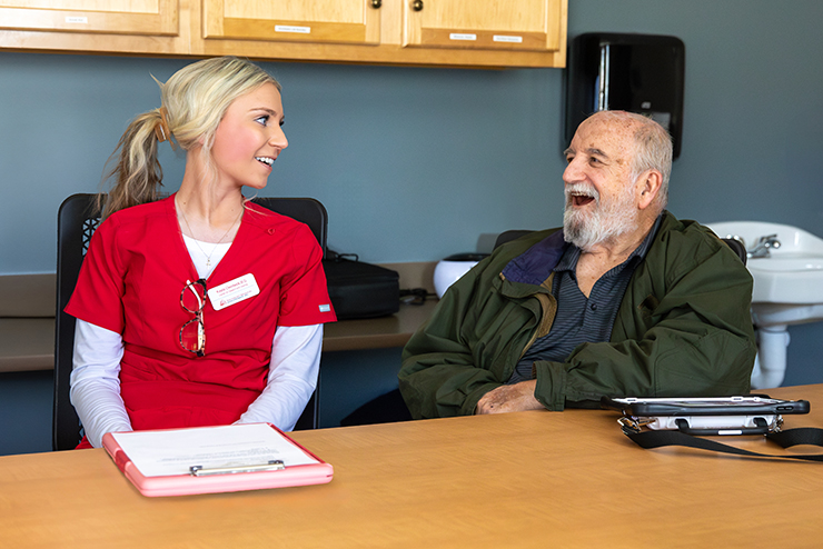 A Communication Disorders student looks at their notebook during a session.  
