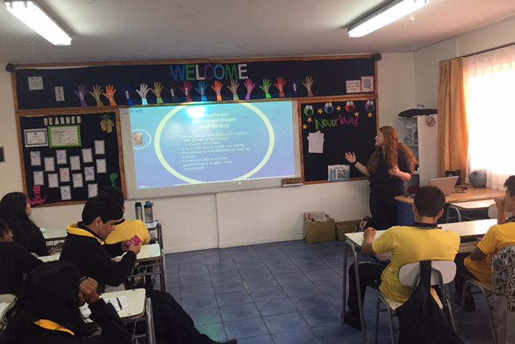 A student teacher teaches a lesson to a class during study abroad. 