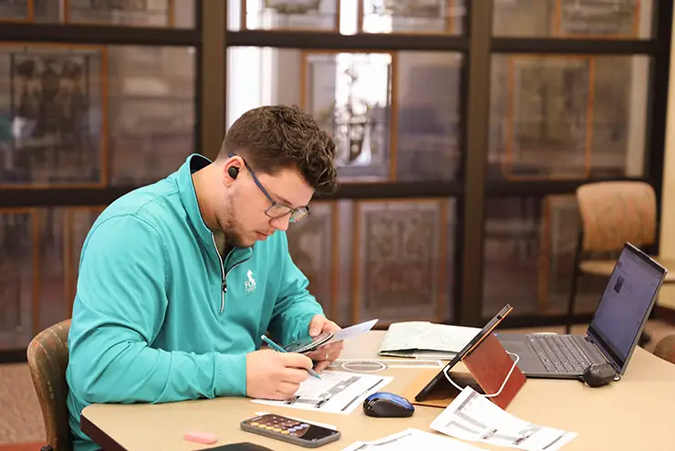 a SEMO student sits at a table and works on an assignment