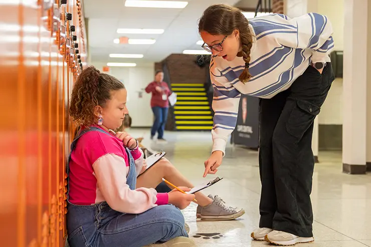 a SEMO student teacher works with a high school student on a lesson