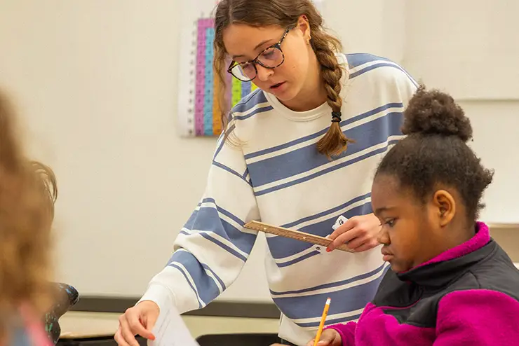 a SEMO middle school education student teacher works with a pupil in a middle school classroom