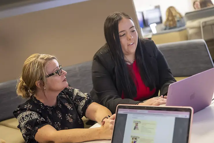 a student and a teacher review technology in the edvolution center together