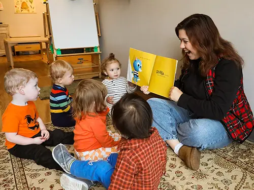 A student at the USYC reads a picturebook to a group of toddlers at semo a top Missouri school for experiential learning