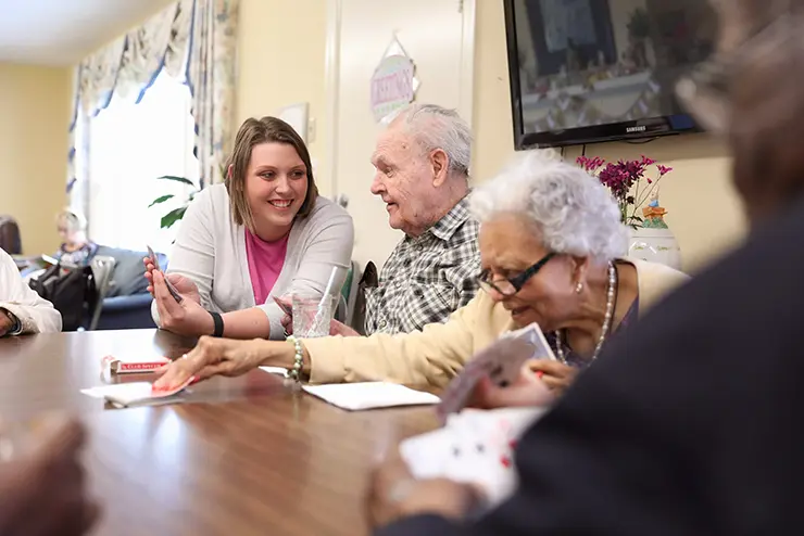 a human development student plays cards with a group of elderly people at SEMO a top Missouri school for experiential learning