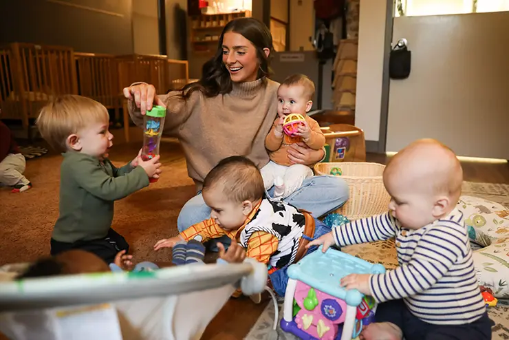 A teacher at the University School for Young Children plays with a group of infants at semo a top Missouri school for experiential learning