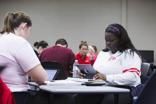  Two students work together in a small group with their iPads. 