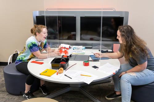 Two students react to the fans spinning on the lego robot they built in the EDvolution Center. 