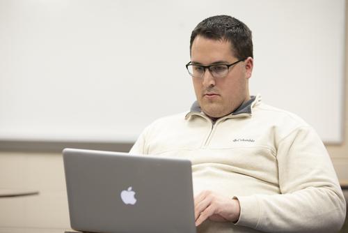 A missouri Psychology student works on their laptop in the classroom.