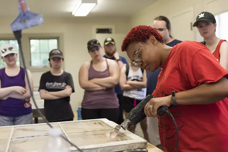 a history field school student works with equipment to restore an old window at semo a Missouri college known for job readiness