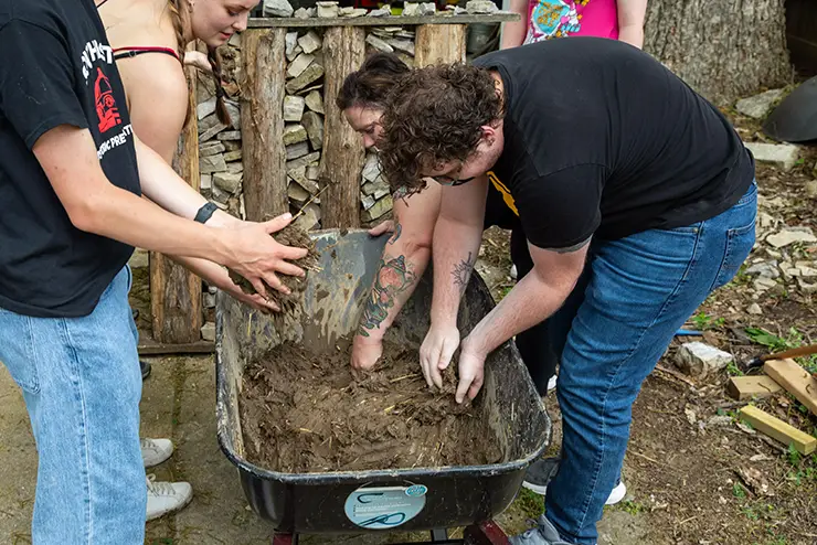 historic preservation students mix mud and straw to build an old-fashioned wall at semo a Missouri college known for job readiness