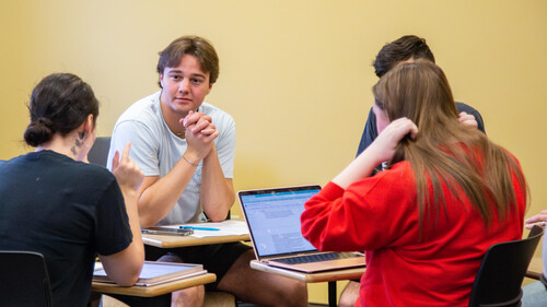 A group of students are sitting in a circle during a workshop.