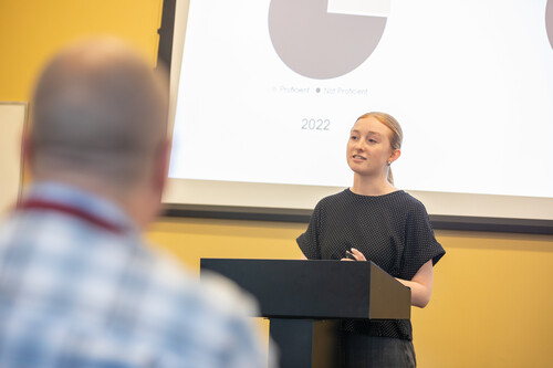 Speech competitors give speeches at a podium.