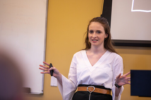 A woman stands in front of the room giving a speech during the speech competition.