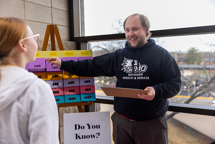 Durng College Night, the speech and Debate club hold a jeopardy-style board.