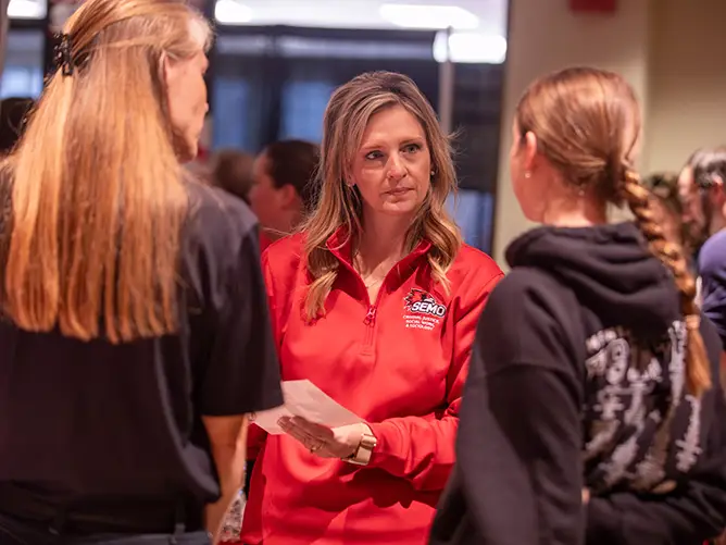 a criminal justice professor talks with her students during an event