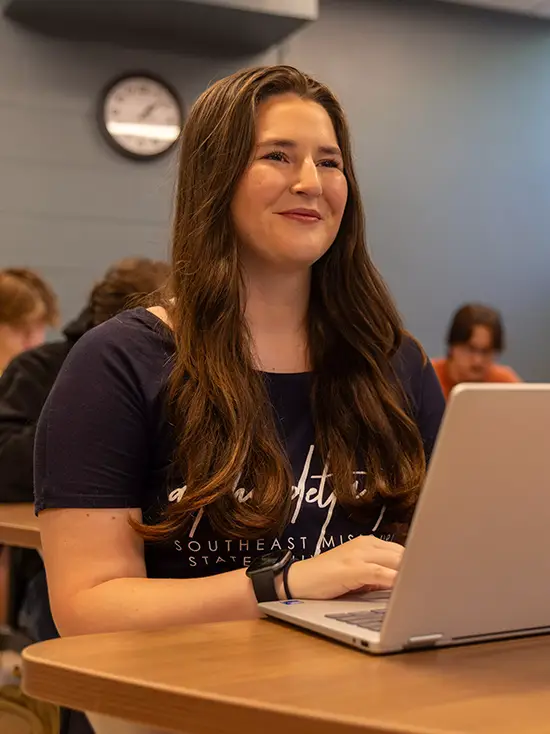 a semo student in Criminal Justice sits at a desk in a classroom with her laptop in front of her