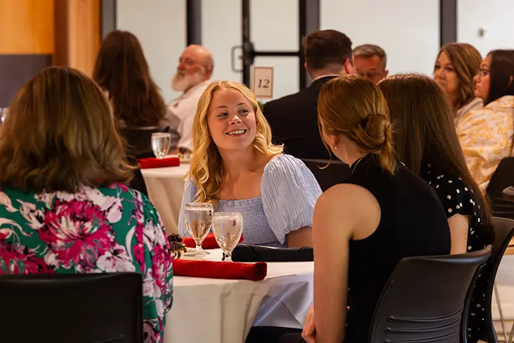 students sit at a dinner table talking and smiling at semo a Missouri college known for job readiness
