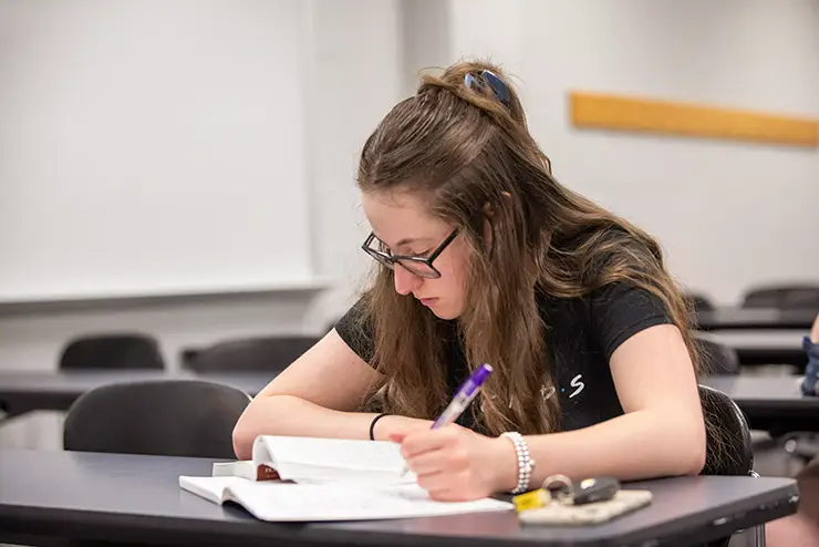 English student takes notes during class at semo a Missouri college known for job readiness