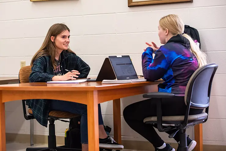 two students work together, one talking the other taking notes at semo a Missouri college known for job readiness