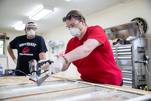 One of the historic preservation participants works on a window.