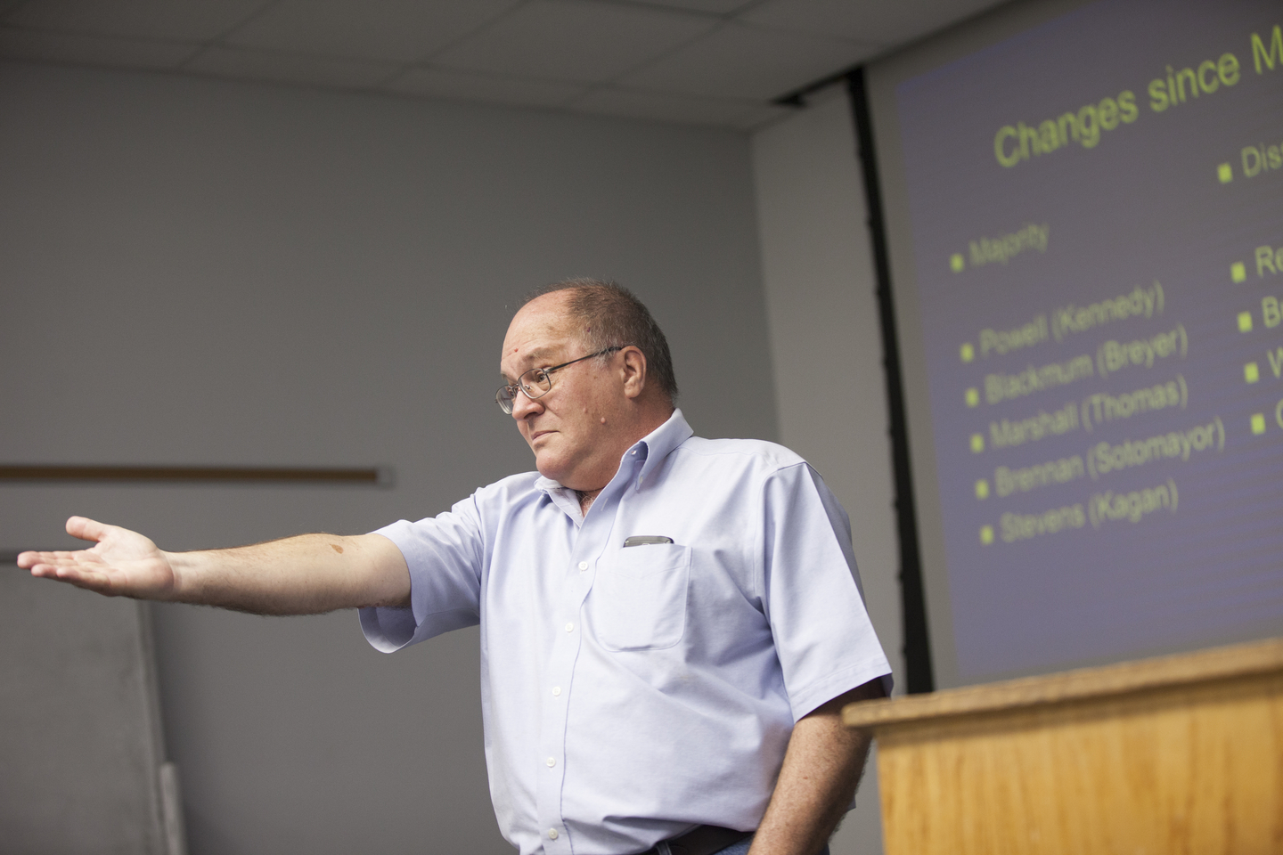 A professor gestures while lecturing during an ethics class.