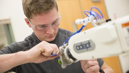 A student works with a piece of machinery in a Seabaugh Polytechnic Building lab.