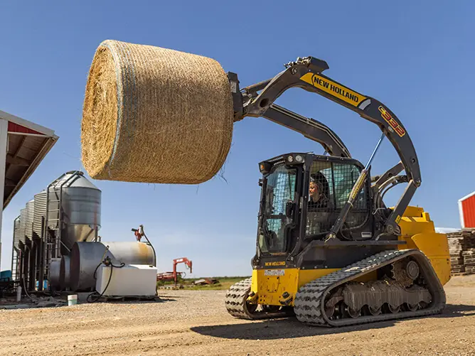 Avery, an agriculture animal science student, operating a skid steer to feed hay to cattle for her agriculture courses in agriculture animal science for her ag degree