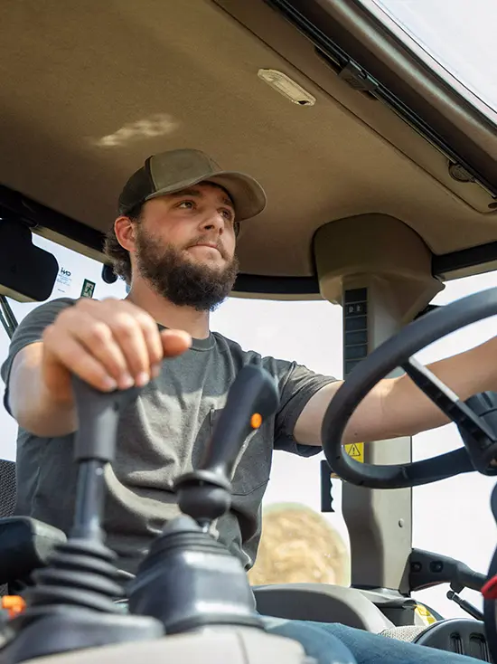 Collin Schabbing, farm manager at the David M Barton Agriculture Research Center operating a tractor where students who are getting an ad degree get hands on experience