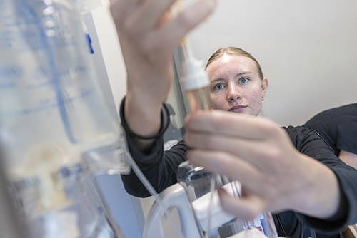a medical student at SEMO works with a bag of IV Fluids