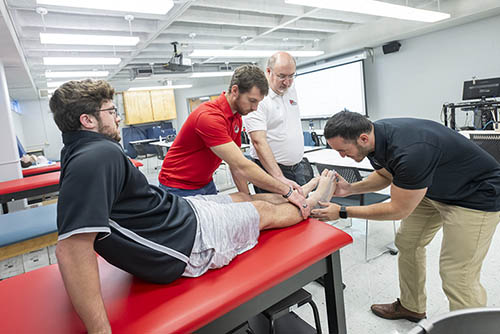 a group of SEMO students inspect a patient's feet
