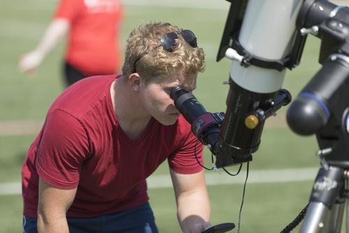 A Southeast Missouri State University physics student use a telescope to examine the moon. 