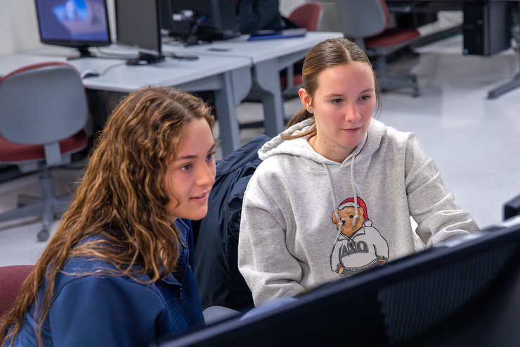 Students work at computer stations.