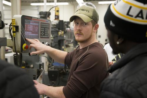A piece of equipment is explained to a student.