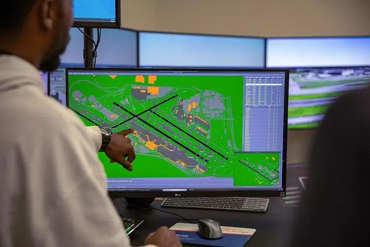 an aviation management student reviews the runway layout on an air traffic control simulator