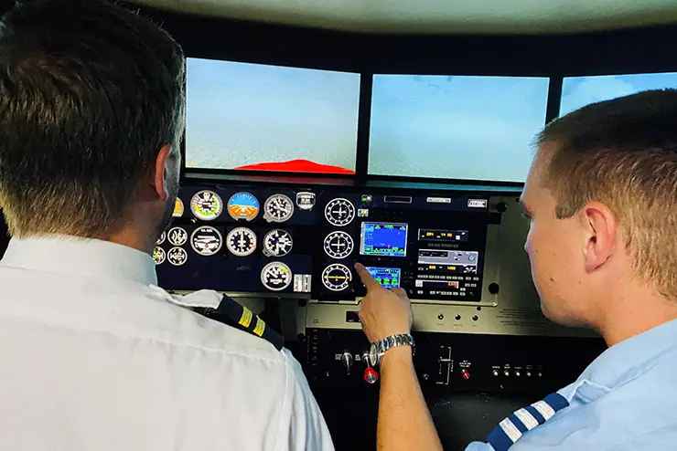 an instructor and a student in the SEMO aviation program go over a simulated instrument panel