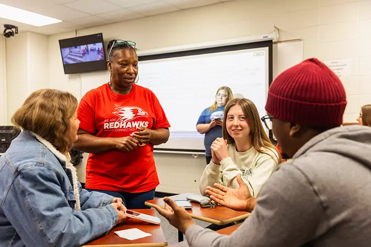 An instructor speaks to a group of studnets during class