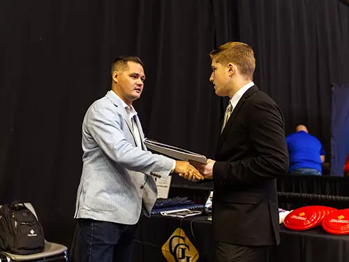 a SEMO student shakes hands with a business owner during the semo career expo