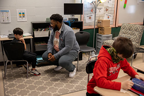 a SEMO student teacher kneels down to speak with a child in the classroom